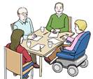 Vier Personen sitzen zusammen an einem eckigen Tisch, eine davon im Rollstuhl